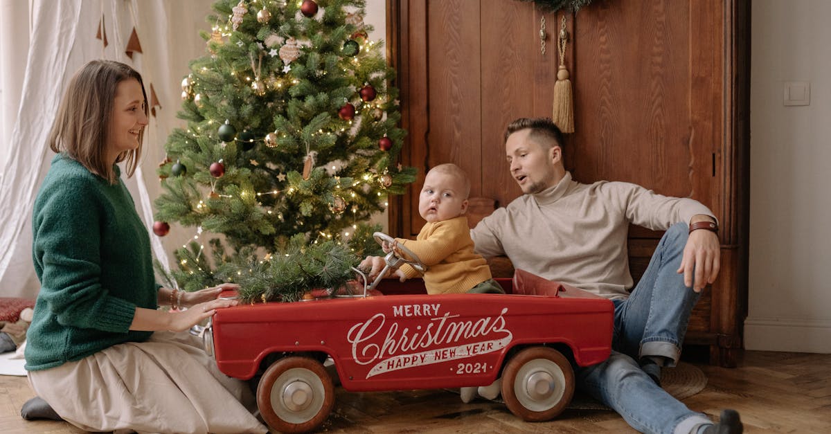 A happy family celebrating Christmas with a decorated tree and festive wagon indoors.