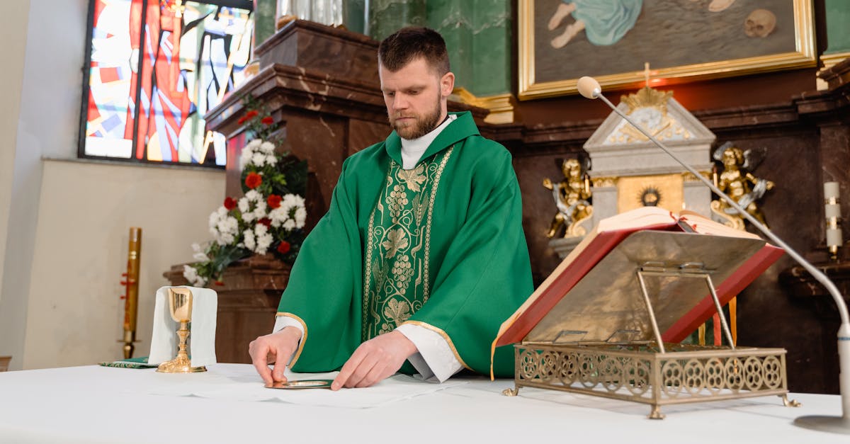 A priest in green vestments preparing for a religious ceremony at a church altar.