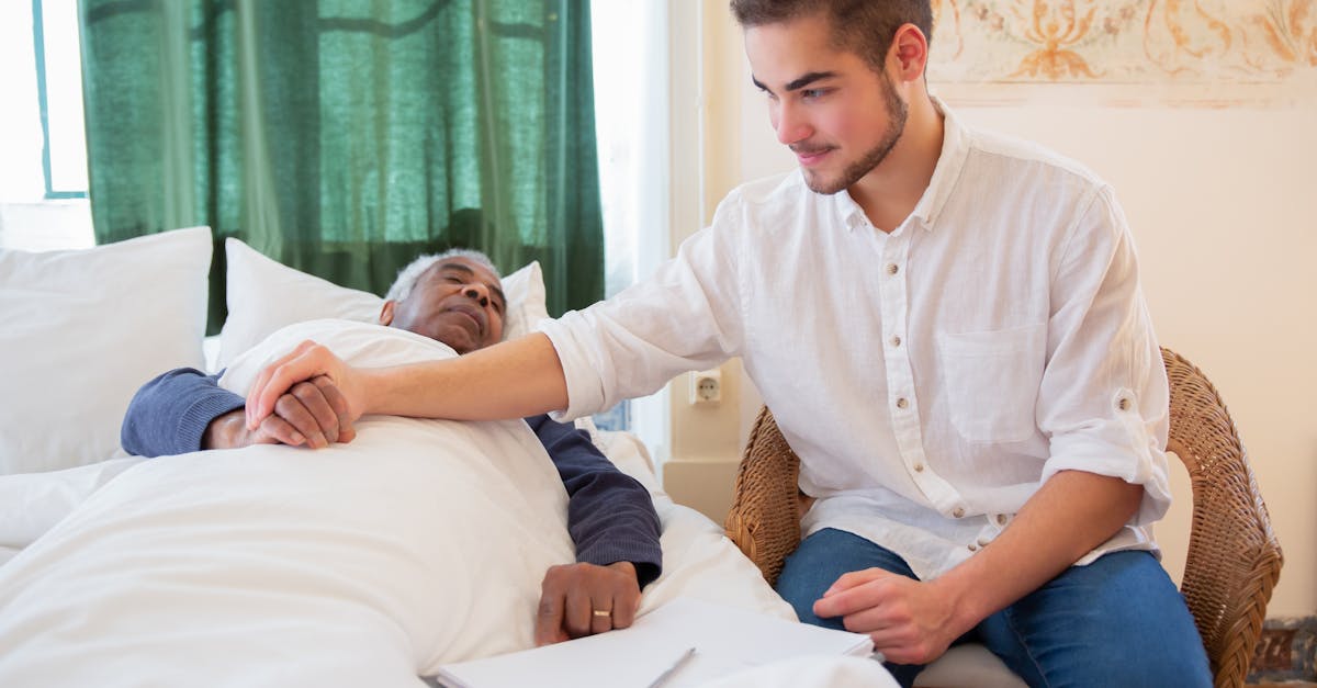 A young man comforts an elderly man in bed, foster warmth and care.