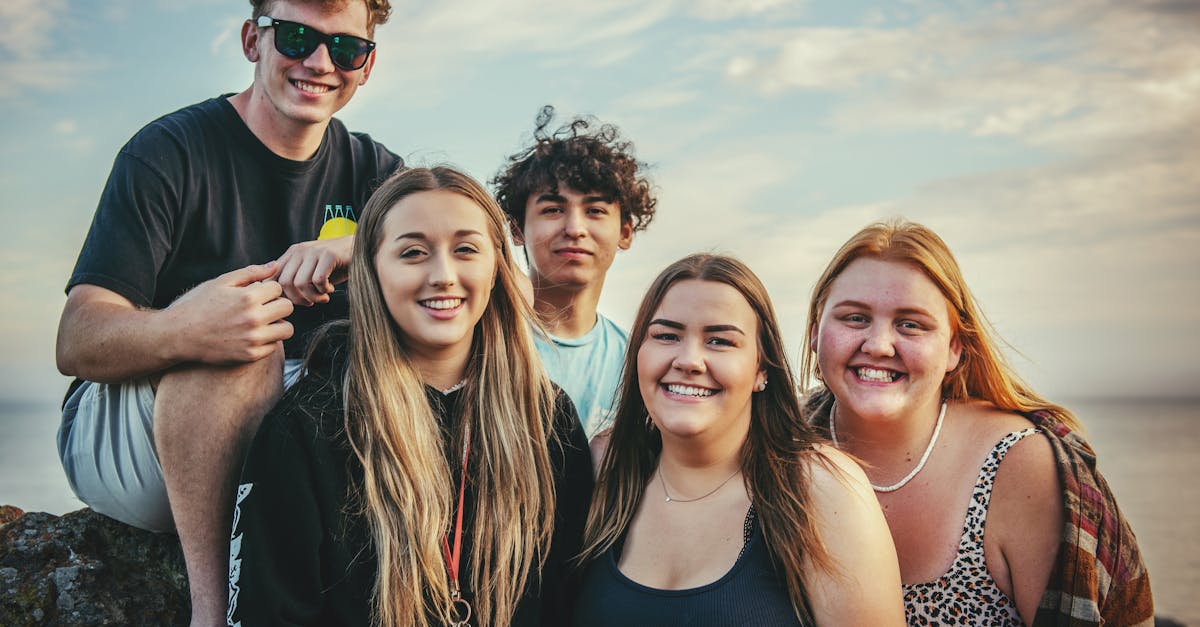 Happy young friends posing and smiling together at Avila Beach, California during a sunny day.